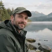 Portrait d’un homme d’une quarantaine d’années en casquette et veste imperméable, au bord de l’eau